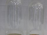 deux bocaux en verre transparent aux bords dorés posés sur une surface blanche