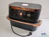an image of a black and copper oven sitting on top of a counter