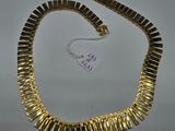 a gold necklace on a white background with a tag