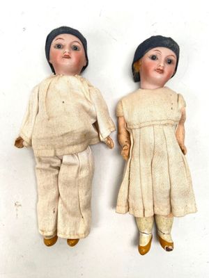 two dolls that are standing next to each other