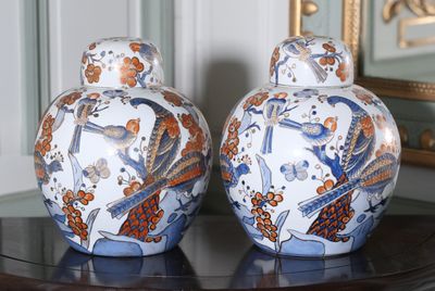 deux vases posés sur une table, avec un miroir en arrière-plan