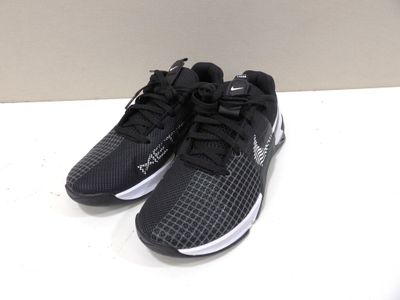 Les chaussures de course Nike noires et blanches sont posées sur une surface blanche