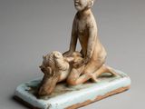 figurine of a woman sitting on a tray with a goat