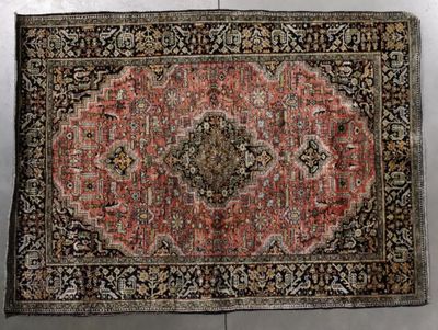 an antique rug with a medallion design on a black ground