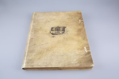 un vieux livre posé sur une table à côté d'une table blanche