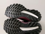 the soles of a pair of black and pink shoes on a box