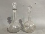 two glass vases sitting next to each other on a table