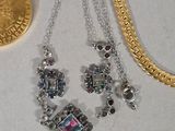 two necklaces and a coin sitting on a table