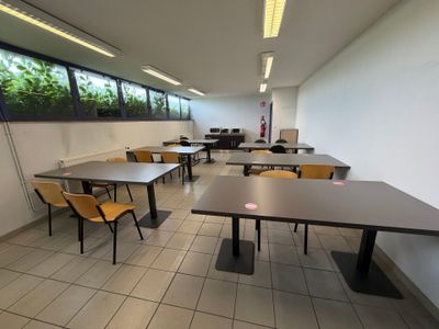 des tables et des chaises dans une pièce dotée d'une grande fenêtre