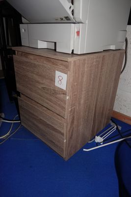 une imprimante blanche posée sur une commode en bois