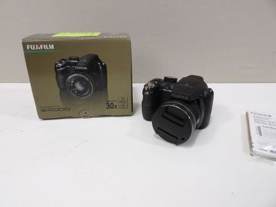 a black camera sitting on a table next to a box