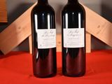 two bottles of wine sitting on a red table cloth