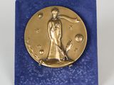 une image représentant une médaille d'or et une femme tenant une raquette de tennis