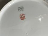 a white plate with a red flower on it
