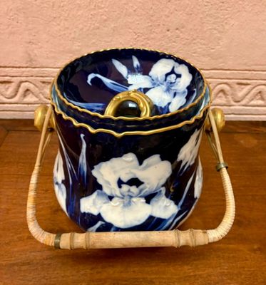 un seau à glace à motifs floraux bleus et blancs posé sur une table en bois
