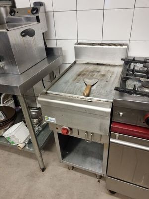 une cuisine équipée d'une cuisinière, d'un évier et d'un four