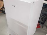 a white refrigerator that is sitting in the middle of a room