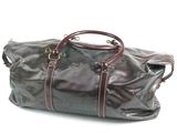 un sac de voyage en cuir marron posé sur une surface blanche