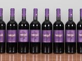 six bottles of wine are lined up on a table