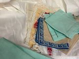a pile of folded towels on a bed next to a pillow