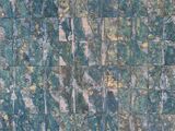 an image of a close up of a stone wall with green and gold paint