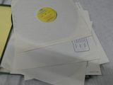 a stack of envelopes and a cd sitting on a bed