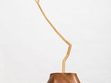 a small wooden vase sitting on top of a white pedestal