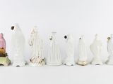 seven figurines of different sizes and shapes on a white surface