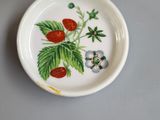 a small plate with strawberries on it on a table