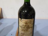 une bouteille de vin posée sur une table avec des baguettes