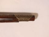 a wooden pen with a metal handle on a white surface