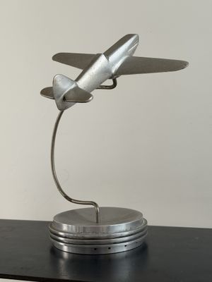 une maquette en métal d'un petit avion posée sur une table