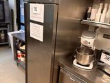a large stainless steel refrigerator in a kitchen with shelves