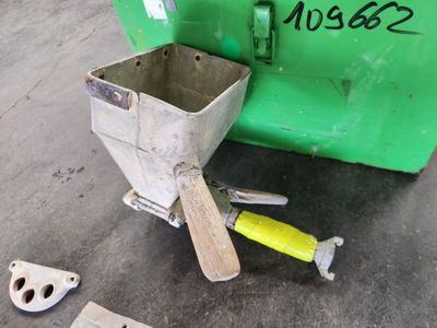 une poubelle verte et quelques outils posés par terre