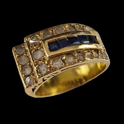 gros plan d'une bague en or avec saphirs et diamants