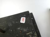 une boîte noire sur laquelle est collé un autocollant, à côté d'une boîte marron sur laquelle est collé un autocollant