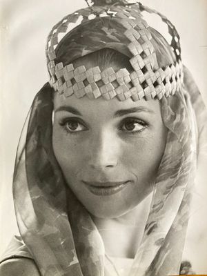 an old black and white photo of a woman wearing a headdress