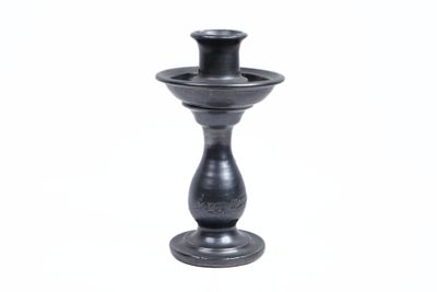 un bougeoir noir sur fond blanc