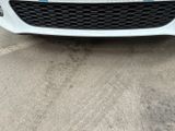 the front end of a white car with a blue stripe on it