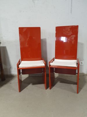 pair of orange chairs with white cushions in a room
