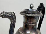 a silver vase with a dragon head on it