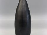 a black vase that is sitting on a white table