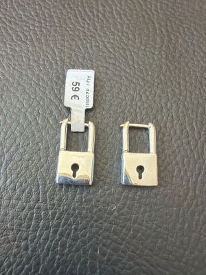 two pieces of metal that have been placed on a leather surface