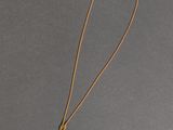 un collier de perles noires et blanches monté sur une chaîne en or