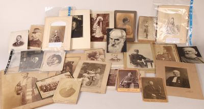 Un assortiment de vieilles photographies d'hommes et de femmes est exposé sur une table