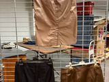 three pairs of pants hanging on a rack in a room