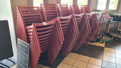 many red chairs lined up in a row in a restaurant
