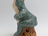 ceramic figurine of a frog sitting on a tree stump