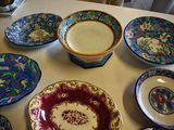 many plates and bowls sitting on a table together