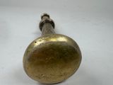 a brass knob on a white table with a white background